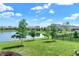 Landscaped backyard with a pond view, framed by mature trees and a decorative black metal fence at 1499 Avondale Dr, Westfield, IN 46074