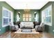 Elegant living room with green walls, stylish furniture, and natural light from two large windows at 1499 Avondale Dr, Westfield, IN 46074