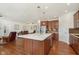 Open-concept kitchen featuring a large island, warm wood floors, and seamless flow into the living area at 1590 Blackthorne N Trl, Plainfield, IN 46168