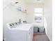 Well-lit laundry room with a washer, dryer, and storage shelf at 1590 Blackthorne N Trl, Plainfield, IN 46168