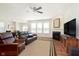 Spacious living room showcasing wood floors, a fireplace, ample natural light, and a ceiling fan at 1590 Blackthorne N Trl, Plainfield, IN 46168