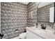 Stylish powder room with patterned wallpaper, elegant mirror, and modern vanity at 1603 Nowland Ave, Indianapolis, IN 46201