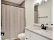 The bathroom features a shower with a striped curtain, a white vanity, and a framed mirror at 1603 Nowland Ave, Indianapolis, IN 46201