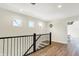 Bright hallway with wood floors and black railing offers a view to a bedroom at 1603 Nowland Ave, Indianapolis, IN 46201