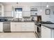 Bright kitchen features white and gray cabinetry, stainless steel appliances, and modern pendant lighting at 20834 Waterscape Way, Noblesville, IN 46062