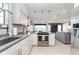 Open-concept kitchen with stainless steel appliances, white cabinetry, and view into the living room at 20834 Waterscape Way, Noblesville, IN 46062