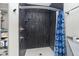 Shower features black vertical tile, modern fixtures, and a blue patterned curtain at 20834 Waterscape Way, Noblesville, IN 46062