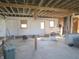 Unfinished basement featuring windows, concrete floors, and exposed wooden beams at 210 Evergreen St, Morgantown, IN 46160