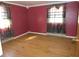 Cozy bedroom featuring red walls, wood floors and natural light at 210 Evergreen St, Morgantown, IN 46160