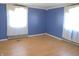 Bright bedroom featuring blue walls, hardwood floors, and bright sunlight at 210 Evergreen St, Morgantown, IN 46160