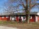 Charming exterior of home with red siding, white trim, a lawn with mature tree and lovely landscaping at 210 Evergreen St, Morgantown, IN 46160