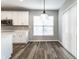 Dining area features wood flooring, a modern light fixture, white cabinets and a large window at 2352 Somerset Cir, Franklin, IN 46131