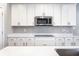 Bright kitchen with white cabinets, quartz countertops, stainless steel microwave, and gray subway tile backsplash at 2352 Somerset Cir, Franklin, IN 46131