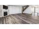 Open-concept living room with fireplace, stylish wood-look floors, and a staircase at 2352 Somerset Cir, Franklin, IN 46131