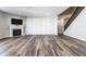 Open-concept living room with fireplace, stylish wood-look floors, and a staircase at 2352 Somerset Cir, Franklin, IN 46131
