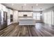 Open concept living and kitchen area with stainless steel appliances, white cabinets, and wood flooring at 2352 Somerset Cir, Franklin, IN 46131