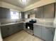 Kitchen featuring gray cabinets, stone countertops, stainless steel oven appliance, and a window at 238 N 7Th Ave, Beech Grove, IN 46107