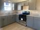 Updated kitchen with sleek gray cabinets, modern appliances, granite countertops, and stainless steel sink at 238 N 7Th Ave, Beech Grove, IN 46107