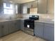 Updated kitchen with sleek gray cabinets, modern appliances, granite countertops, and stainless steel sink at 238 N 7Th Ave, Beech Grove, IN 46107
