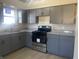 Updated kitchen with sleek gray cabinets, modern appliances, granite countertops, and stainless steel sink at 238 N 7Th Ave, Beech Grove, IN 46107