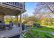 Covered back patio with outdoor seating, stone patio and a beautifully landscaped backyard pond at 241 Melissa Ann Ct, Indianapolis, IN 46234