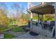 Covered back patio with outdoor seating, mature trees, and lush landscaping at 241 Melissa Ann Ct, Indianapolis, IN 46234