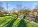 Backyard features lush green grass, mature trees, gravel paths, and manicured landscaping at 241 Melissa Ann Ct, Indianapolis, IN 46234