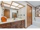 Bathroom with wood vanity and large tub with a mirrored accent wall at 241 Melissa Ann Ct, Indianapolis, IN 46234