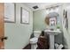 Stylish half bathroom with pedestal sink, decorative mirror, and modern fixtures at 241 Melissa Ann Ct, Indianapolis, IN 46234
