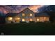A picturesque stone home at dusk, featuring warm interior lighting and a beautiful sunset backdrop at 241 Melissa Ann Ct, Indianapolis, IN 46234