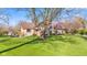 Beautiful stone home with a lush green lawn, mature trees, and a welcoming front yard at 241 Melissa Ann Ct, Indianapolis, IN 46234