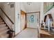 Inviting foyer featuring textured walls, a decorative front door, and staircase access to upper levels at 241 Melissa Ann Ct, Indianapolis, IN 46234