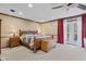 Bright main bedroom featuring a wood bed frame, red curtains, and a door to a balcony at 241 Melissa Ann Ct, Indianapolis, IN 46234