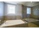 Modern bathroom with a separate tub and glass-enclosed shower, featuring tile accents and natural light at 30 W Main St # 3D, Carmel, IN 46032
