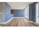 Bright living room featuring hardwood floors, blue accent wall, and large windows at 30 W Main St # 3D, Carmel, IN 46032