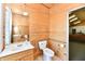 Well-lit bathroom with wooden walls, a vanity, and a toilet with a safety bar for accessibility at 302 S Sherman Dr, Indianapolis, IN 46201