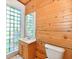 Bathroom featuring tiled walls, a vanity with sink, toilet and decorative glass block window at 302 S Sherman Dr, Indianapolis, IN 46201