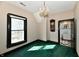 A bedroom with green carpet, a wall clock, and a bathroom at 302 S Sherman Dr, Indianapolis, IN 46201