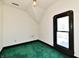 A bedroom featuring green carpet, bright window, and minimal lighting at 302 S Sherman Dr, Indianapolis, IN 46201