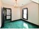 A bedroom with a bright window, dark trim, green carpet, and a chandelier at 302 S Sherman Dr, Indianapolis, IN 46201