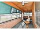 Inviting enclosed porch with vintage wood paneling, brick base, and multiple chairs at 302 S Sherman Dr, Indianapolis, IN 46201