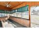 Inviting enclosed porch with vintage wood paneling, brick base, and comfortable chair at 302 S Sherman Dr, Indianapolis, IN 46201