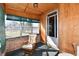 Inviting enclosed porch with vintage wood paneling, brick base, and a comfortable chair at 302 S Sherman Dr, Indianapolis, IN 46201