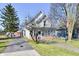 Charming two-story home with an American flag displayed, along with an inviting front porch and long driveway at 302 S Sherman Dr, Indianapolis, IN 46201