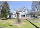 Charming two-story home with brick enclosed porch with many trees in the large yard at 302 S Sherman Dr, Indianapolis, IN 46201