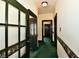 This hallway has green carpet and dark-wood trimmed doors and trim at 302 S Sherman Dr, Indianapolis, IN 46201