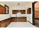 The kitchen features a long counter, dark-wood cabinets, and white tiled floors at 302 S Sherman Dr, Indianapolis, IN 46201