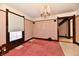 Spacious living room boasts marble floors, original wood trim, chandelier lighting, and pink carpet at 302 S Sherman Dr, Indianapolis, IN 46201
