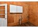 A small room with wood paneling, white wall cabinets, and a wood floor at 302 S Sherman Dr, Indianapolis, IN 46201