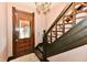 Elegant staircase featuring vintage wood finishes, a crystal chandelier, and a decorative door at 302 S Sherman Dr, Indianapolis, IN 46201